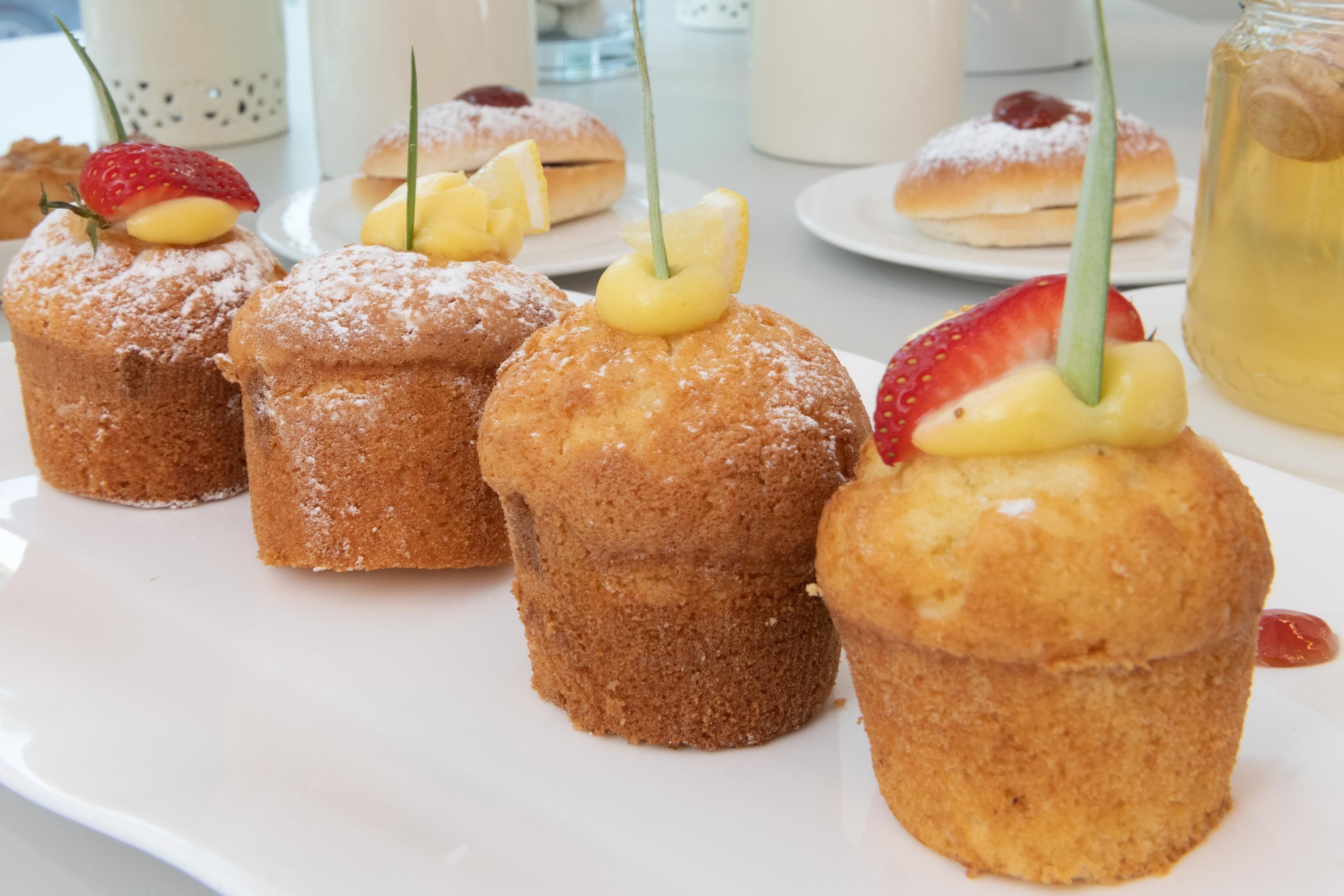 A plate of pastries with fruit toppings and powdered sugar.