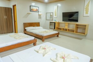 A hotel room with two wooden beds, a TV, a small fridge, and a wooden cabinet. - Panglao Kalikasan Dive Resort (Panglao)