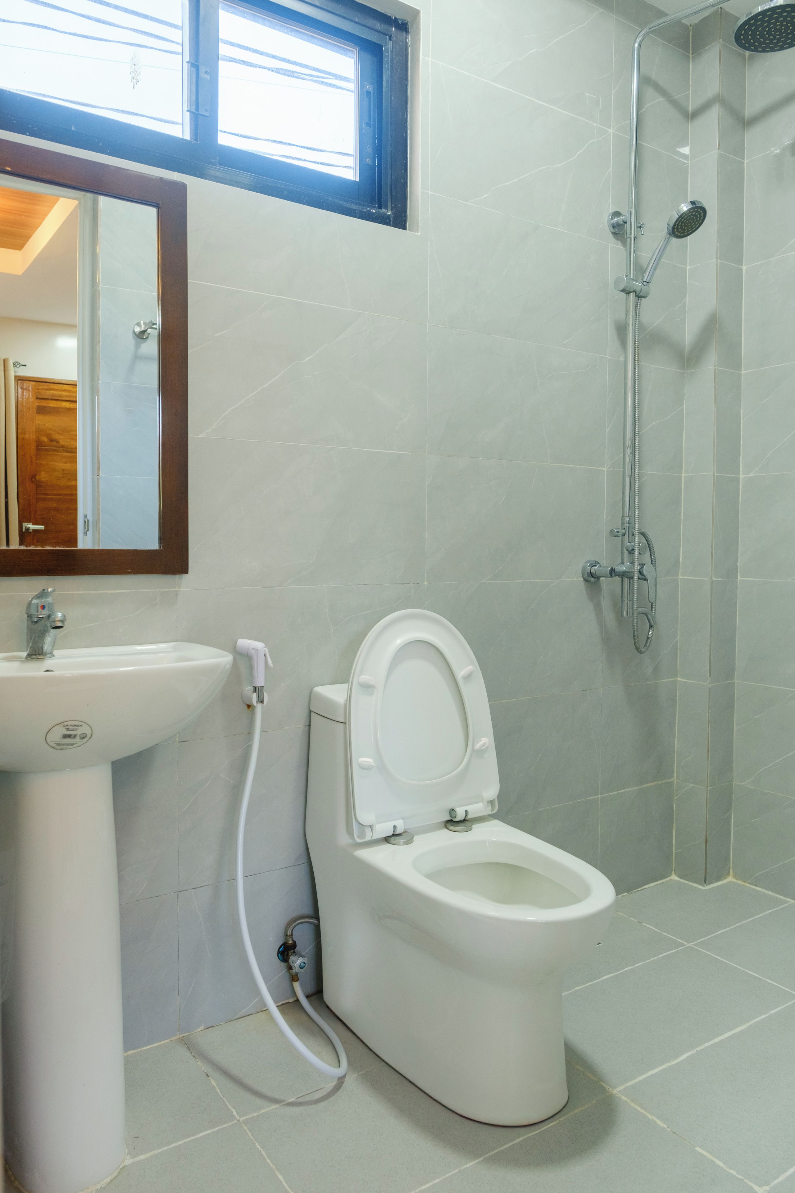 Un baño con inodoro, lavabo y ducha.