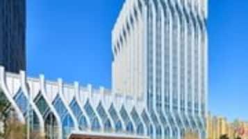 Stunning building with a unique design, featuring a glass facade and a covered seating area.