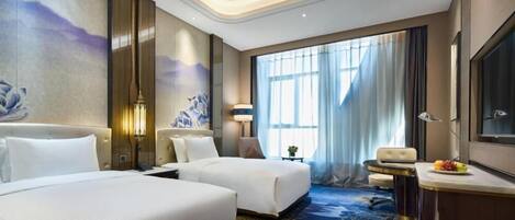 Une chambre d’hôtel avec deux lits, un bureau, une chaise, une télévision et une grande fenêtre avec des rideaux.
