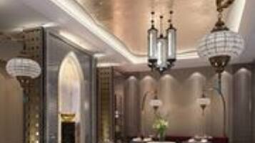 A luxurious hotel lobby with a grand chandelier, elegant seating, and a modern design.