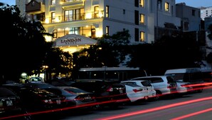 A tall hotel building with illuminated signage at the top. - London Hanoi Hotel (Hanoi)