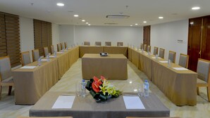 A conference room with a long table, chairs, and a floral centerpiece. - London Hanoi Hotel (Hanoi)