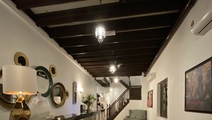 A hallway with a checkered floor, a counter with a lamp, and a staircase leading to another level. - D'Nice Heritage House (George Town)