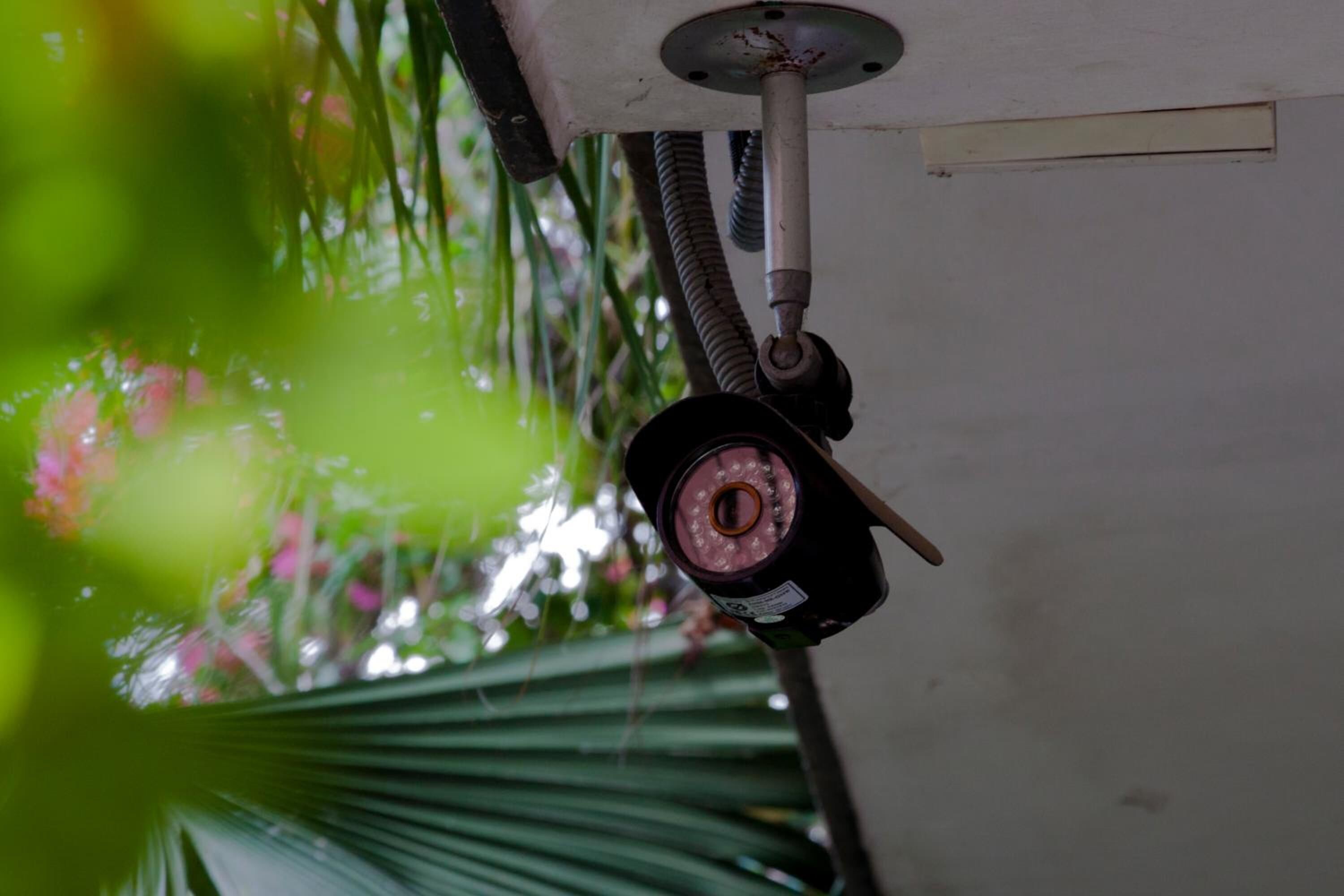 Uma câmara de segurança montada no teto, com lente visível e um cabo.