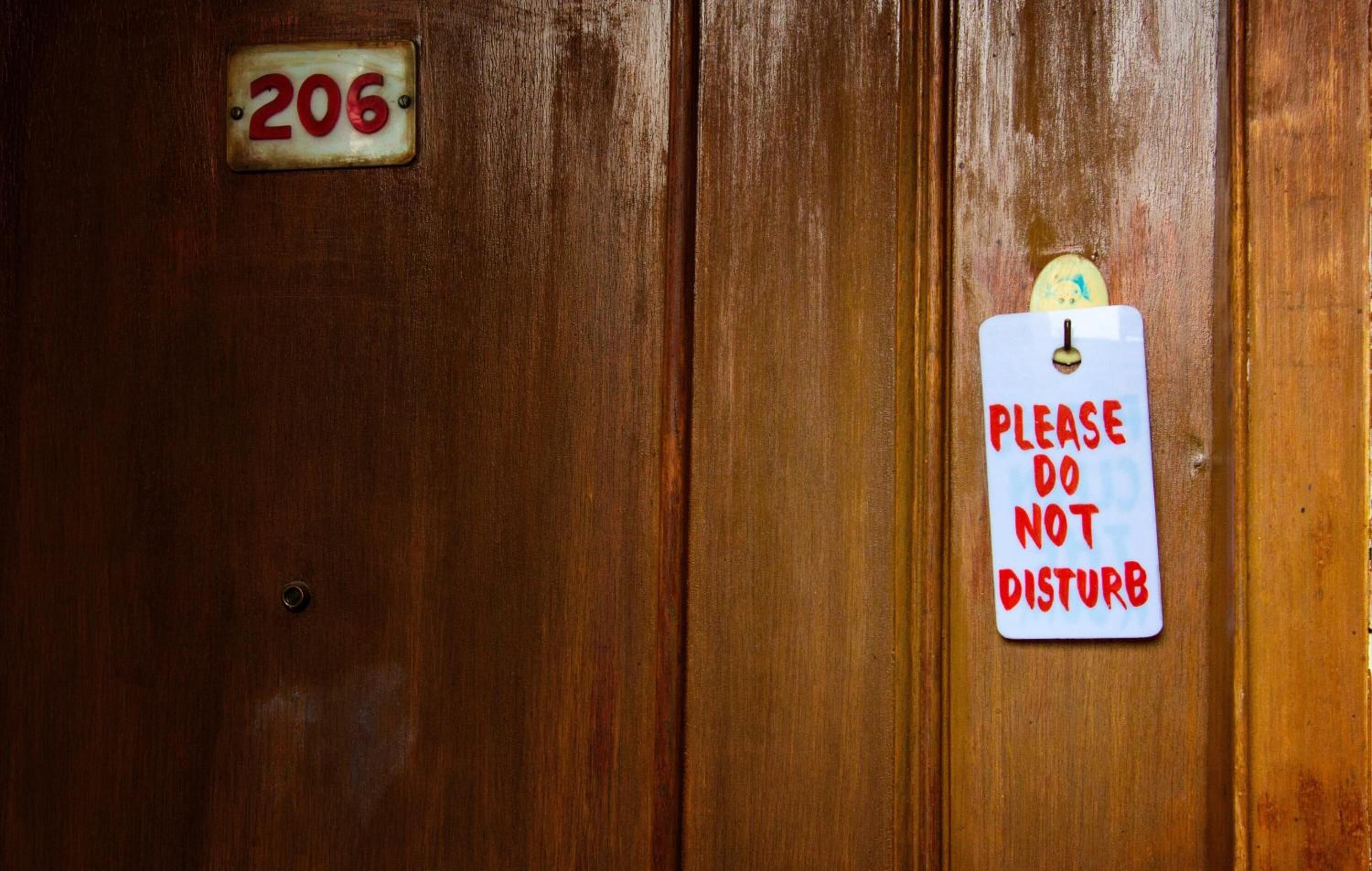 A wooden door with a number plate '206' and a 'PLEASE DO NOT DISTURB' sign.