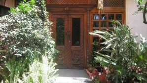 Una entrada de madera tradicional con tallados intrincados y un cartel sobre la puerta.