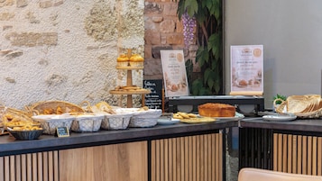 Mostrador de panadería con diversos productos horneados y pan.