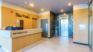 A reception area with a wooden reception desk labeled "INFORMATION" and a "SEA STAR" sign above it. - Sea Star Hostel Yeosu (Yeosu)