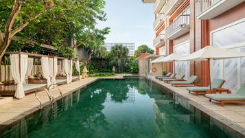 Una piscina al aire libre, tumbonas
