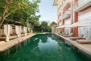 Una piscina al aire libre, sillones reclinables de piscina