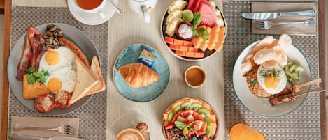 A breakfast spread with various dishes, including eggs, toast, and fruit on a table.