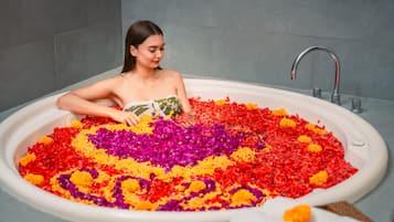 A bathtub filled with colorful flower petals.