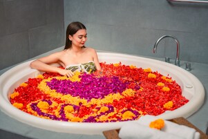 A bathtub filled with colorful flower petals.
