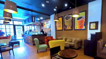 Un café acogedor con suelo de madera, asientos cómodos y decoración moderna.