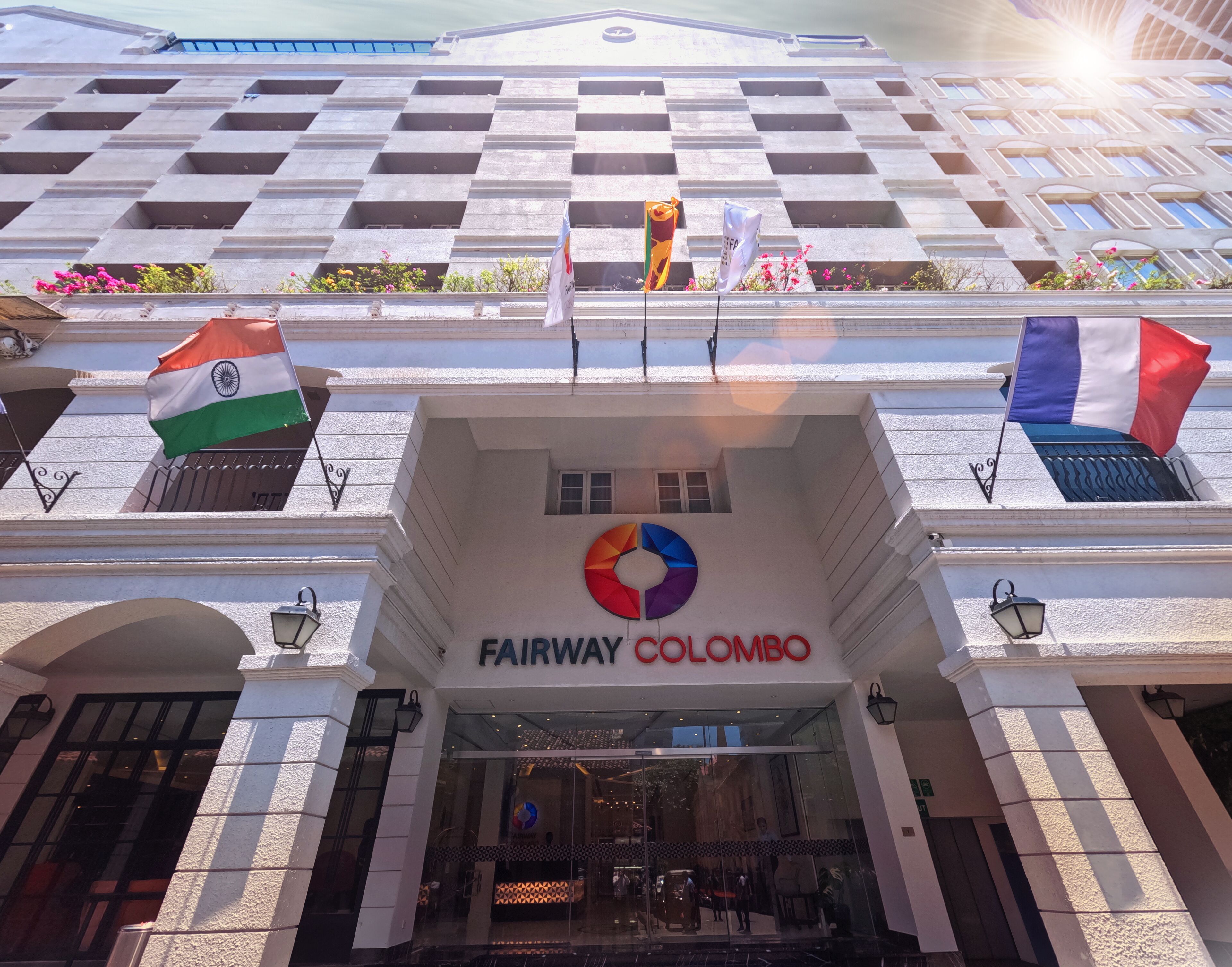 Exterior del Fairway Colombo con banderas y un logotipo.