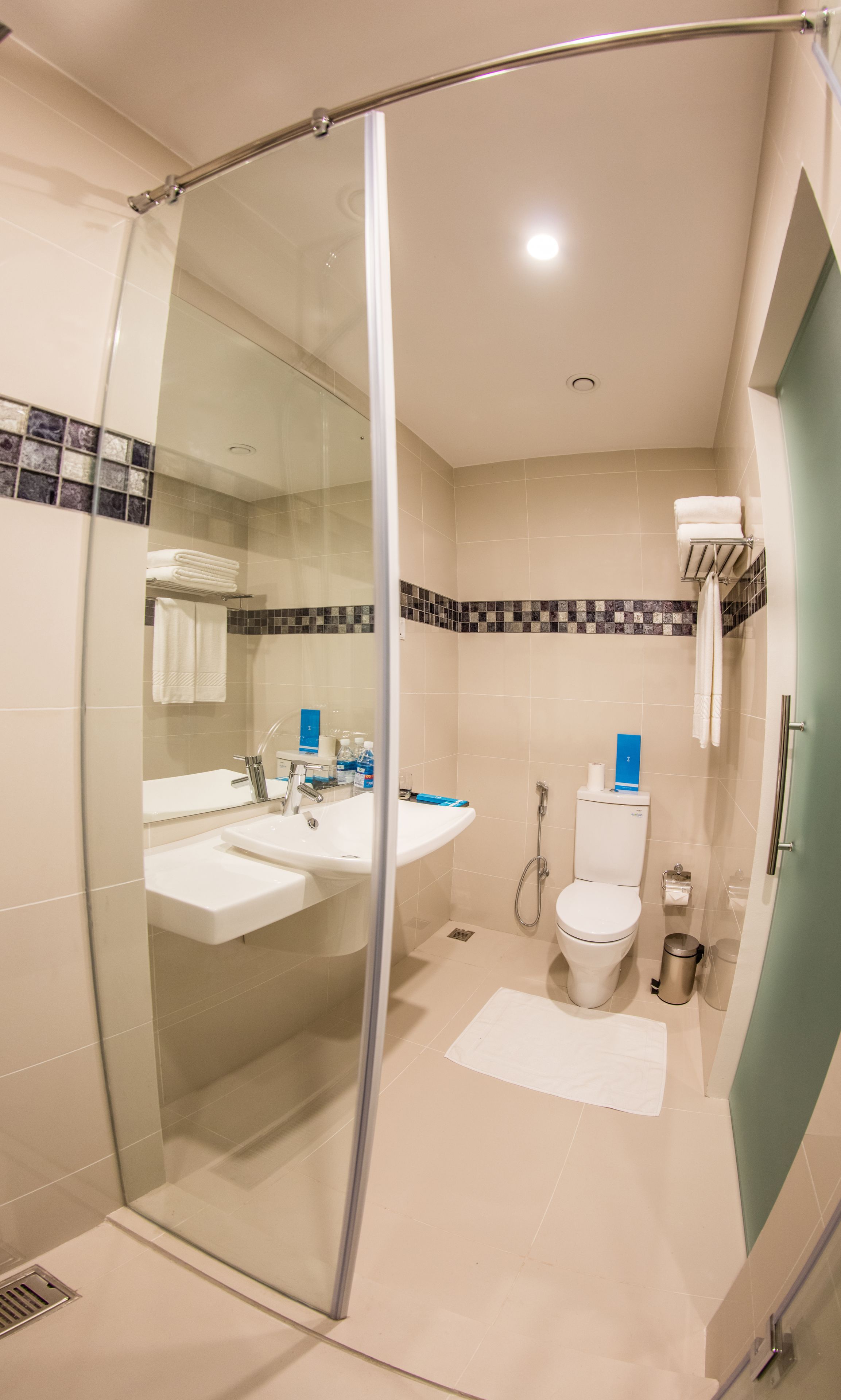 Un bagno moderno con box doccia in vetro, lavabo con specchio, WC e bidet.