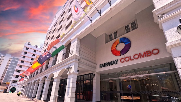 Un edificio con el letrero "Fairway Colombo" y varias banderas, incluyendo las de Reino Unido e India.