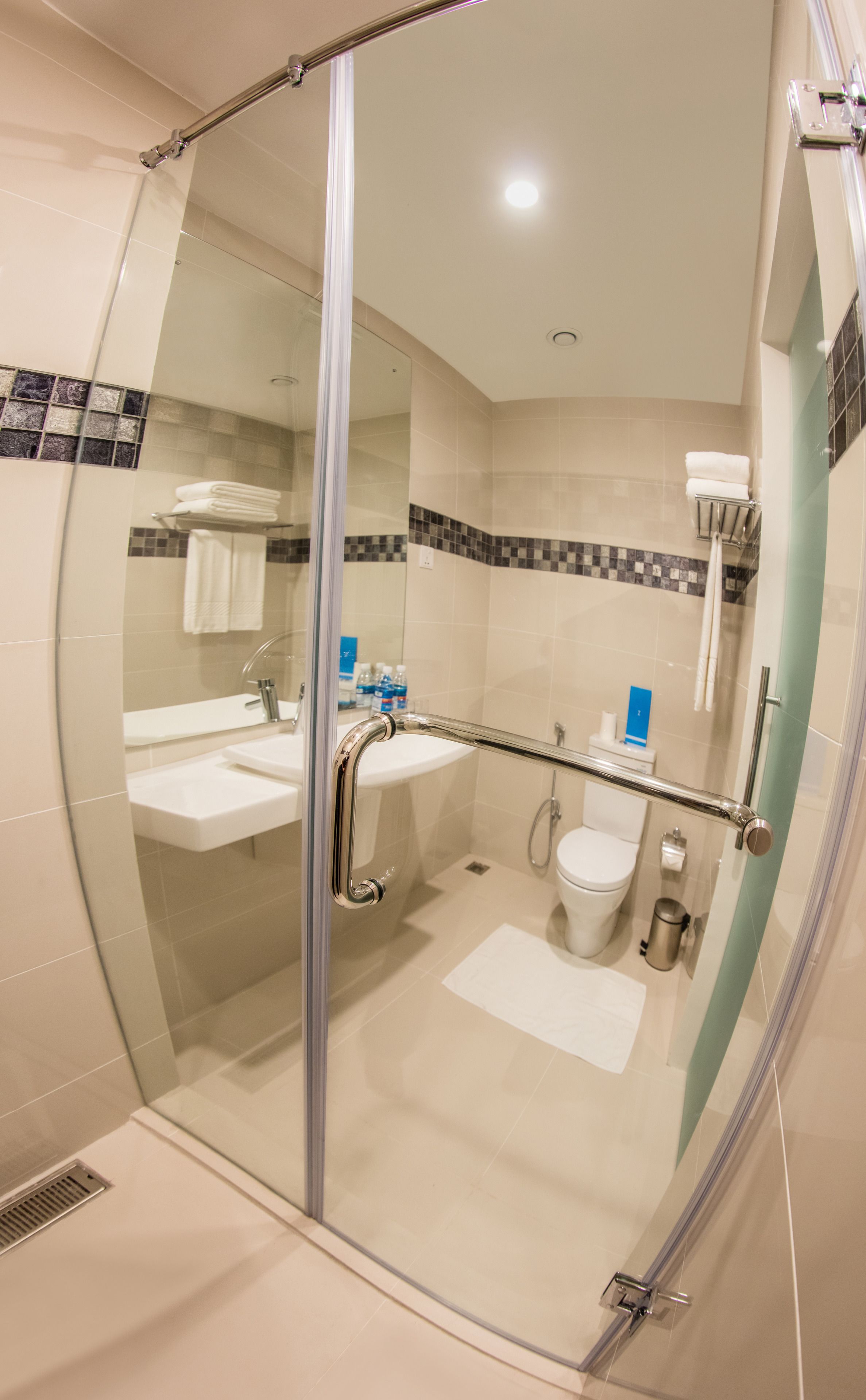 Een moderne badkamer met een douchecabine van glas, een wastafel en een toilet.