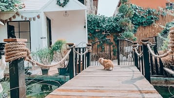 Una terraza de madera que conduce a una casa con techo de paja y un adorno festivo.