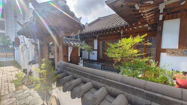 Ein traditionelles japanisches Gebäude mit einem Ziegeldach, Holzbalken und einer Steinbalustrade.