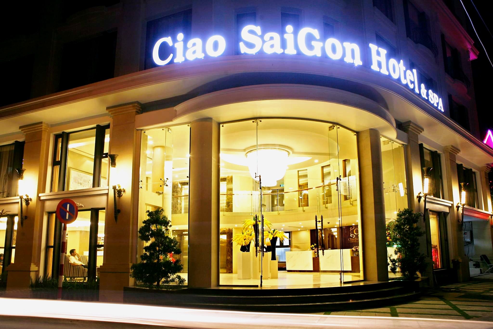 The exterior of Ciao Sai Gon Hotel & Spa with a large illuminated sign, glass entrance, and a reception desk visible inside.