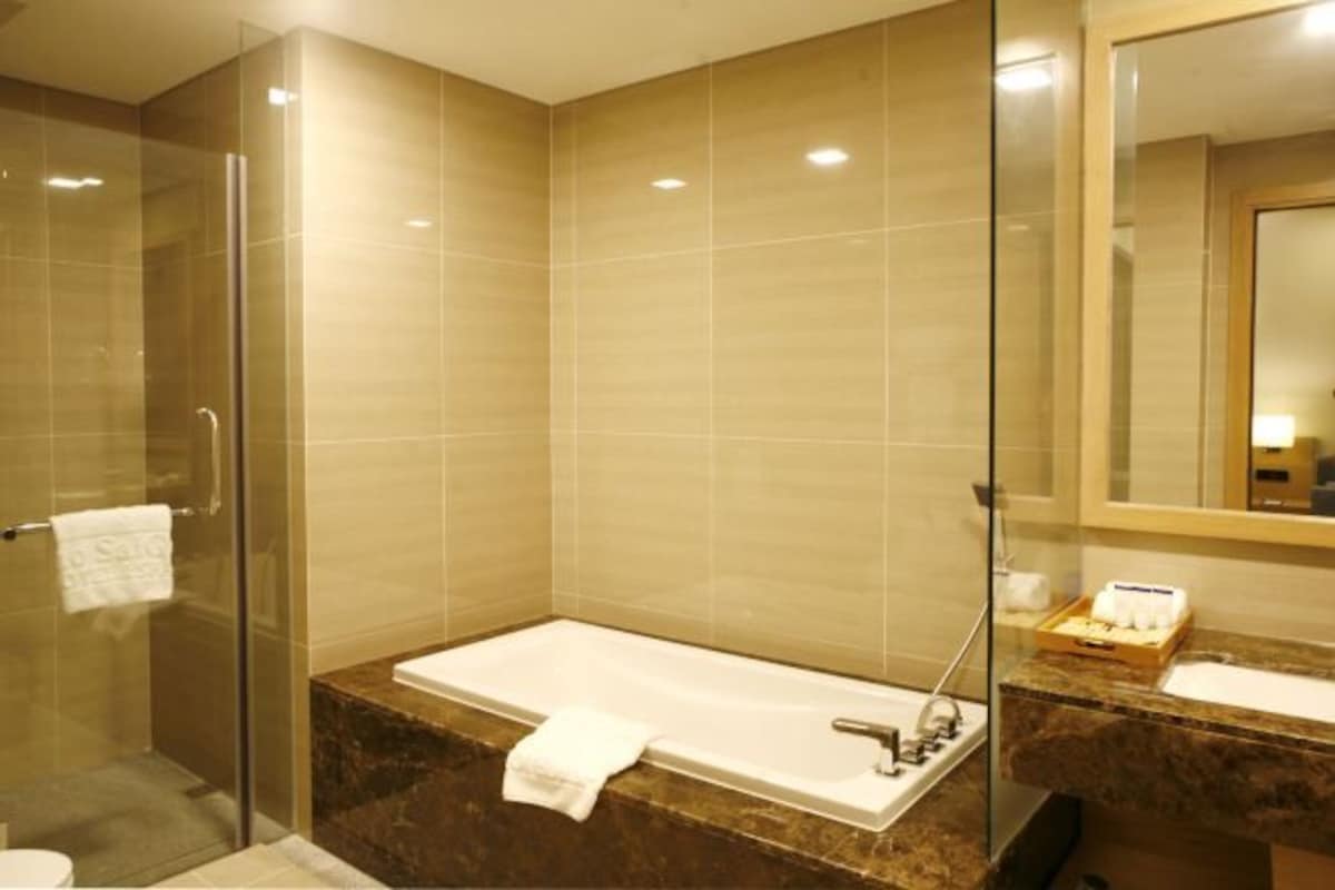 Un baño moderno con ducha de vidrio, una bañera independiente y un lavamanos.
