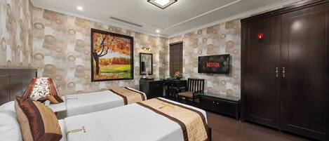 A hotel room with two beds, a desk, a TV, and a wardrobe.