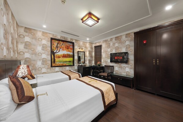 A hotel room with two beds, a desk, a TV, and a wardrobe. - Bay Luxury Binh Anh Grand Hotel (Hanoi)