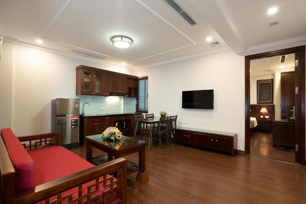 Espaço compacto com cozinha compacta, área de jantar, sofá e televisão.