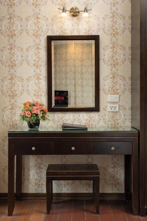 A wooden desk with a mirror, a vase with flowers, and a bench. - Bay Luxury Binh Anh Grand Hotel (Hanoi)