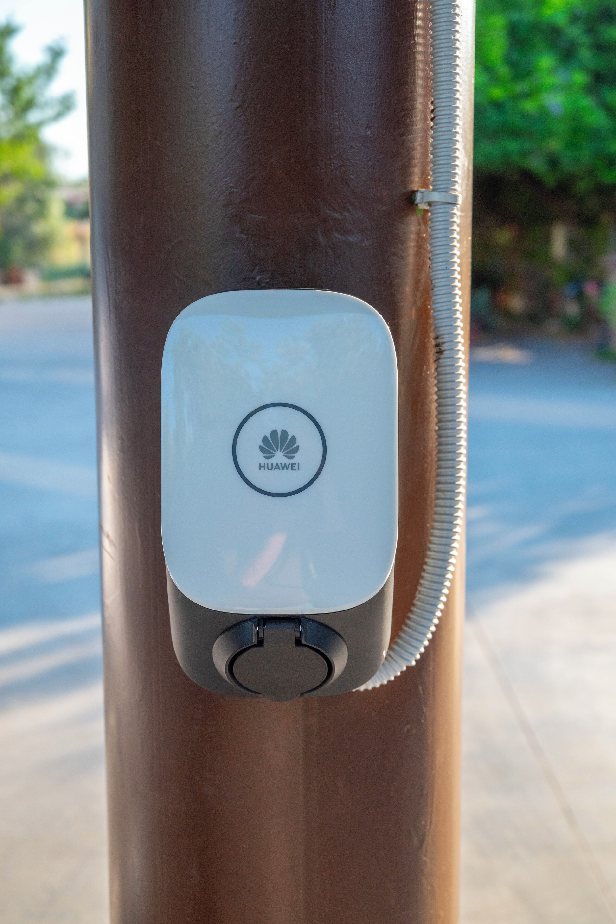 A Huawei device attached to a brown pole.