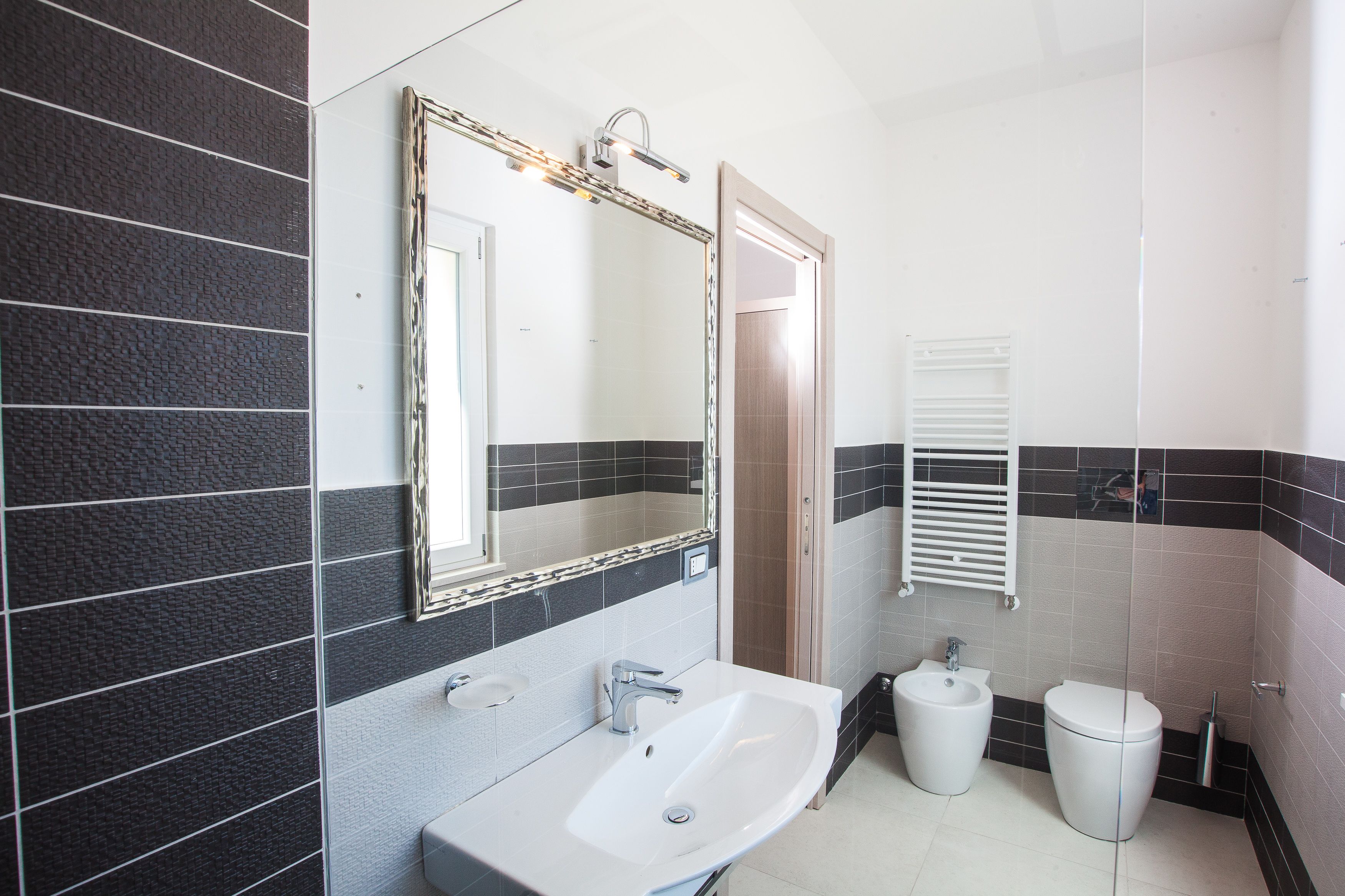 Ein Badezimmer mit Waschbecken, Spiegel, Bidet und Toilette.