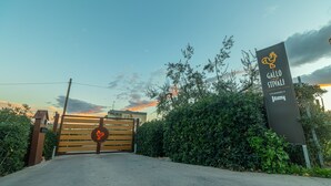 A gated entrance with a sign for Gallo Restaurant, surrounded by greenery and a clear sky. - Il Gallo con gli Stivali (Termoli)