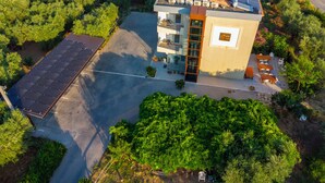A modern building with a rooftop solar panel array, a covered outdoor seating area, and a parking lot. - Il Gallo con gli Stivali (Termoli)