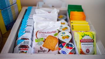 Verschiedene Lebensmittel, darunter Nutella, Brot und Joghurt, in einer Aufbewahrungsbox.
