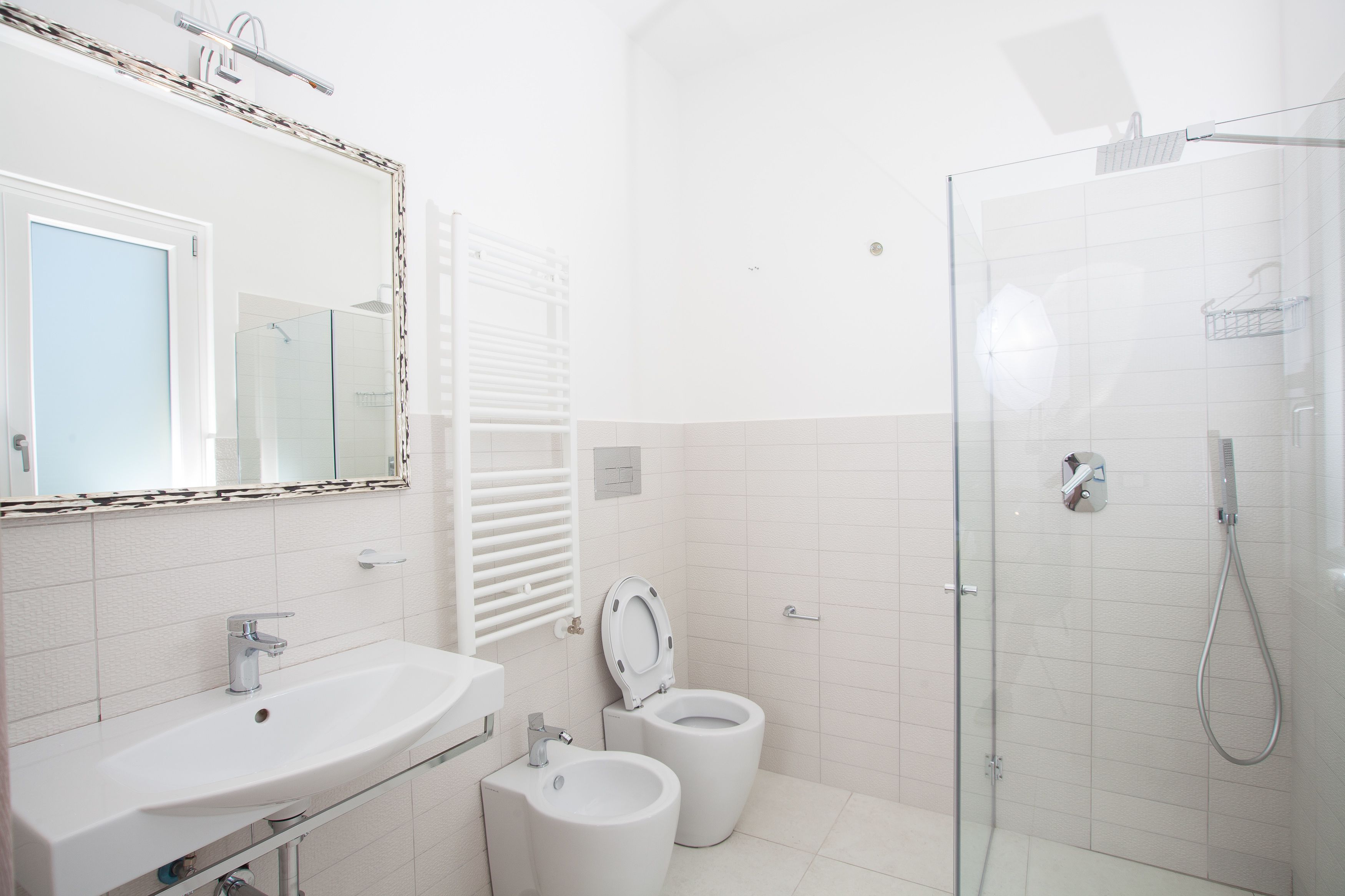 Un bagno con lavandino, WC e doccia.