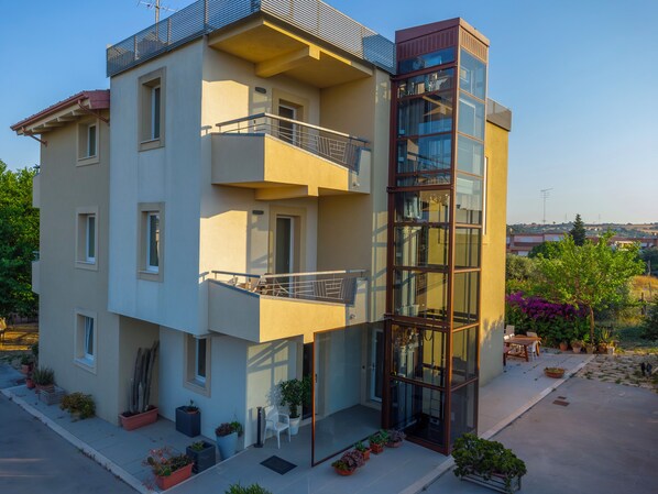 A modern multi-story building with balconies, potted plants, and a clear view of the surrounding area. - Il Gallo con gli Stivali (Termoli)