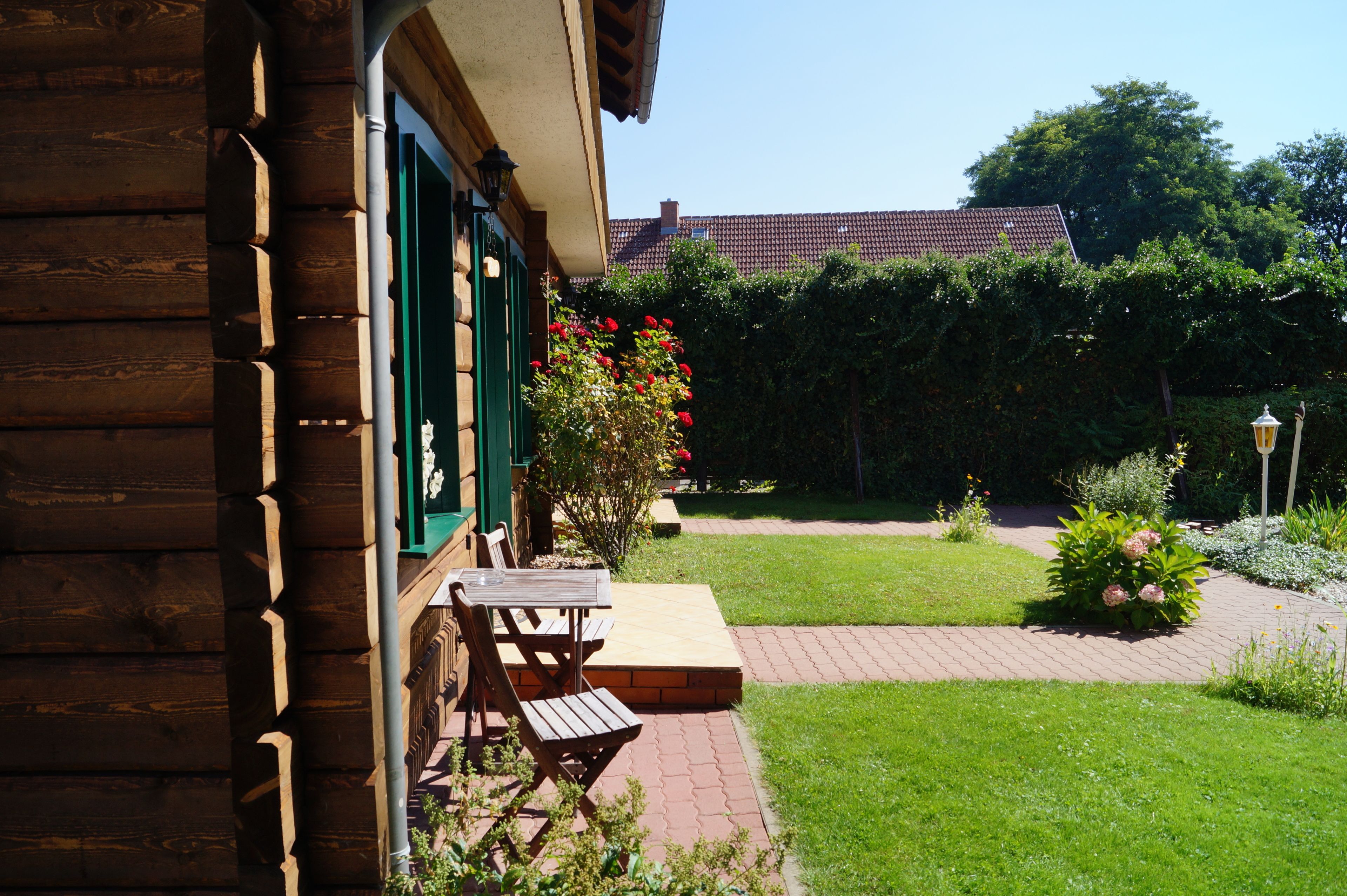 A wooden building with a patio area featuring a bench and a table.