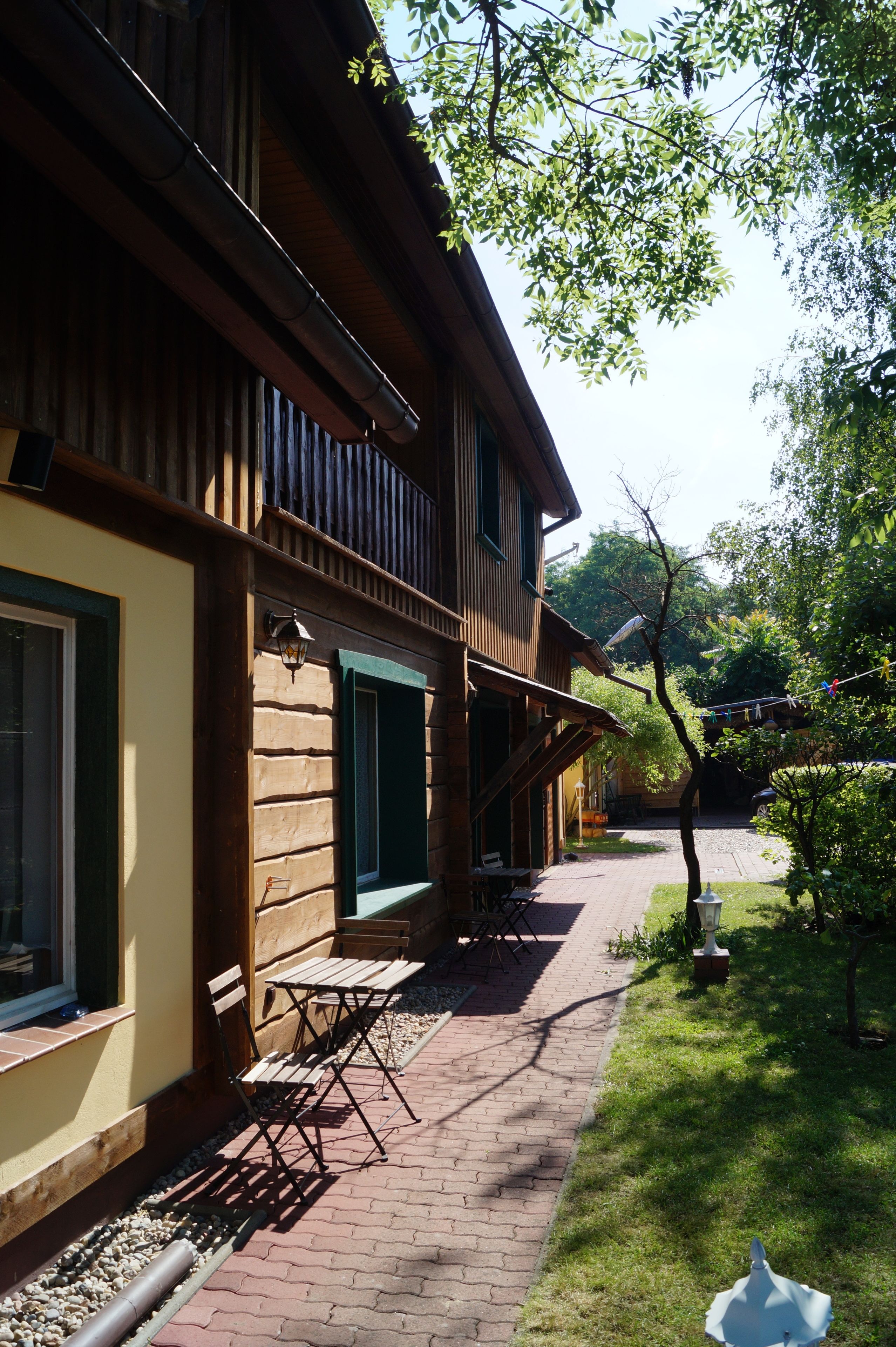 A wooden building with a brick pathway leading to outdoor seating.