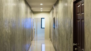 A hallway with a polished floor, a door on the right, and a framed picture on the wall.