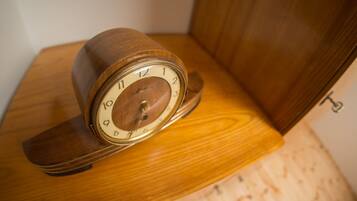 A wooden clock with a white face and black numbers on a wooden surface.