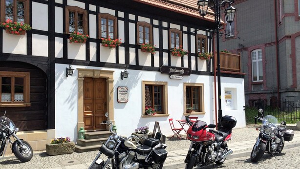 Un bâtiment traditionnel à colombages, sur lequel est apposée une enseigne indiquant qu’il s’agit d’un restaurant.
