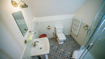 Een badkamer met wastafel, toilet en douche.