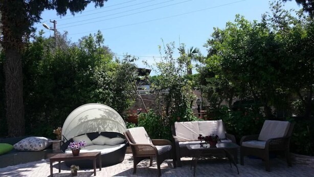 An outdoor seating area with a round table, chairs, and a covered lounge. - Cennet Apart (Bodrum)