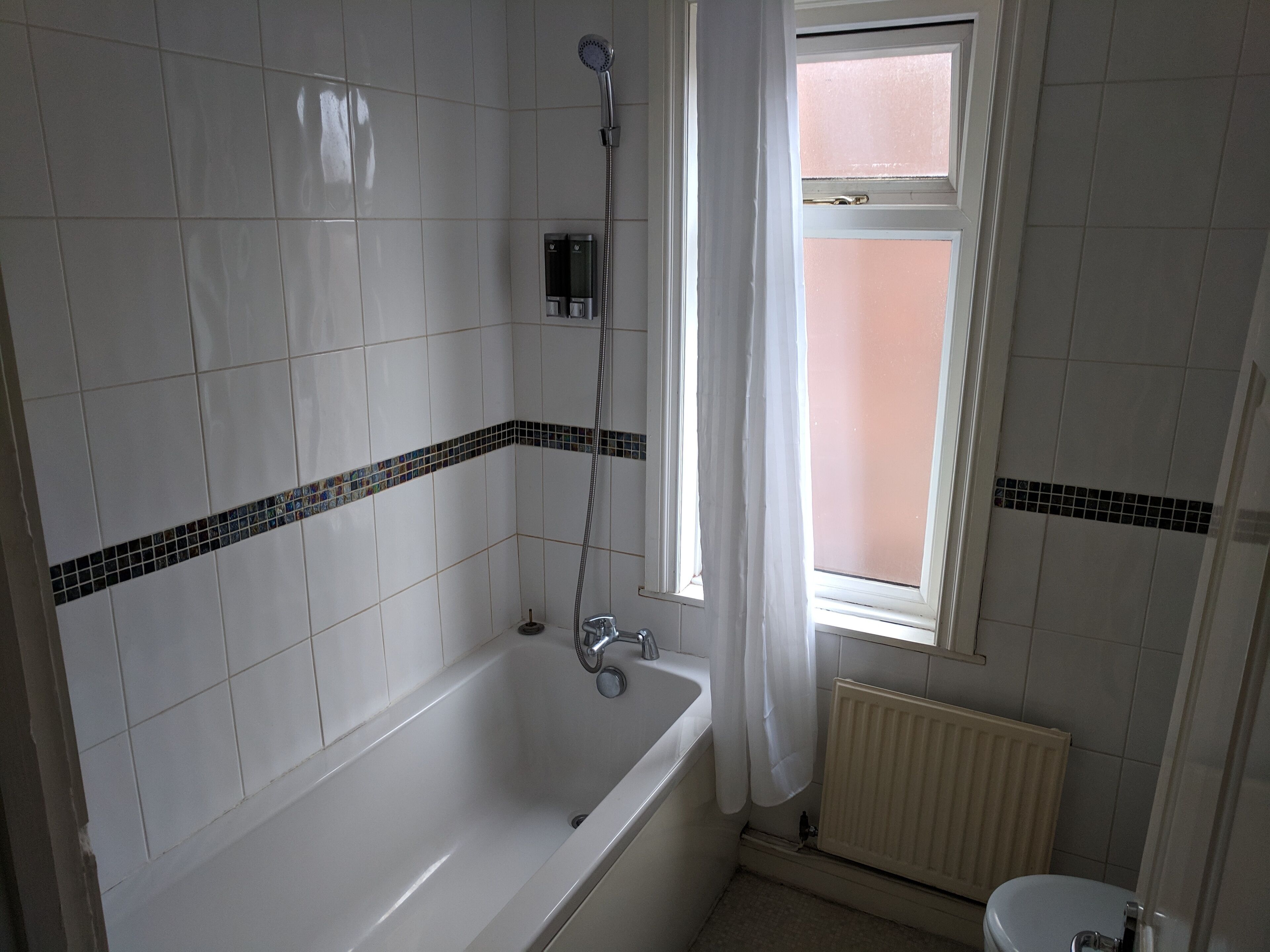 Une salle de bain avec une baignoire, une douche et des toilettes.