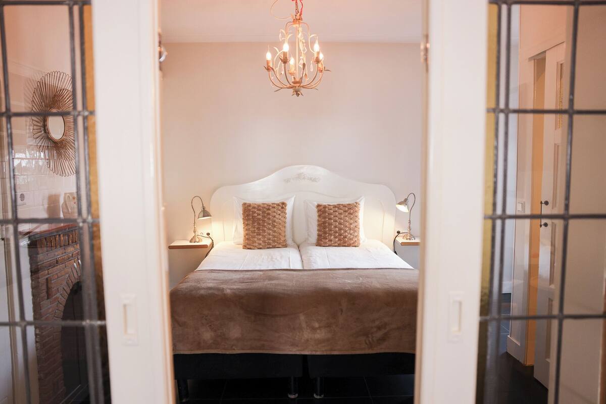 Ein Schlafzimmer mit einem Bett, einer Kandelaber und Nachttischlampen.