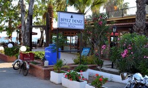 A sign for Bitez Deniz Hotel & Restaurant Beach with outdoor seating and potted plants. - Bitez Deniz Hotel (Bodrum)
