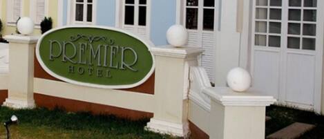 Un letrero de hotel con el nombre "Premier Hotel" y un estilo arquitectónico tradicional con ventanas de arco y detalles decorativos.